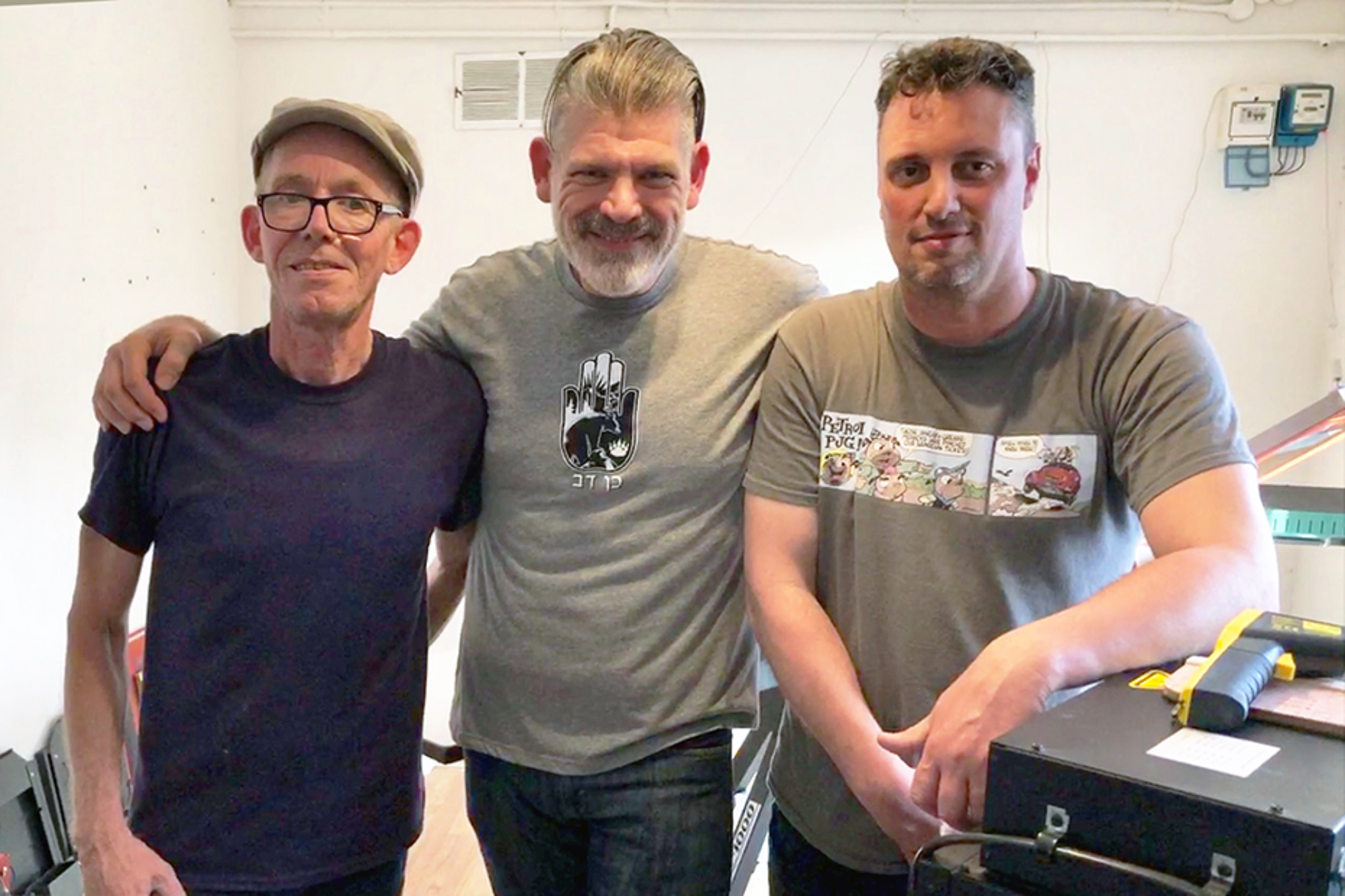 Zenessex Studio refined its techniques with training by Douglas Grigar (center), master screen printer. He is flanked by owners Richard Sharpe (left) and Kevin Burtt (right).